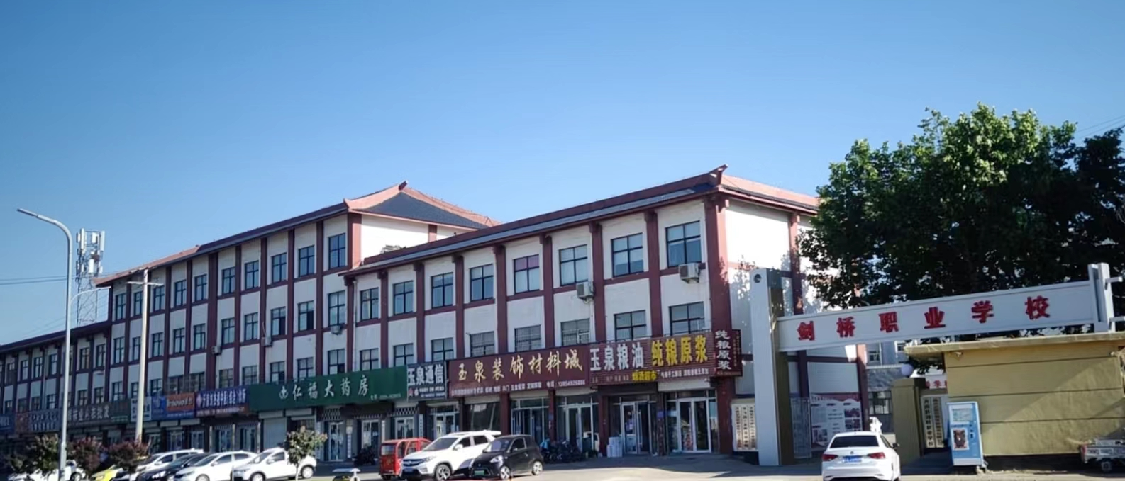 沂南县剑桥职业学校官网首页主视觉，学校楼体与校门